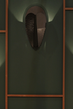 Black perforated metal wizard mask wall lamp. La Chance. 