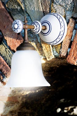 Simple wall lamp with patinated brass rod, decorated white porcelain and smooth opal glass. Aldo Bernardi. 