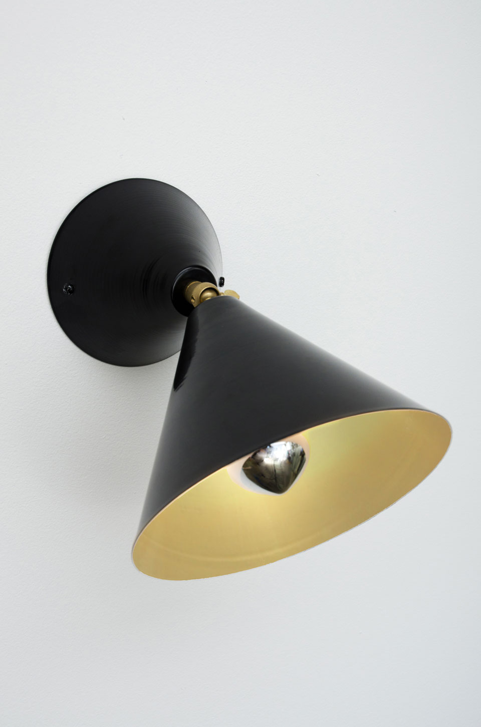 Black wall lamp with golden interior and adjustable cone. Atelier Areti. 