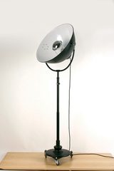 Lampadaire en métal noir sur roulettes, type projecteur . Contract&More. Lampadaire en métal noir sur roulettes, type projecteur . Contract&More.