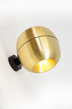 Wall light in the shape of a small golden apple. Dark. 