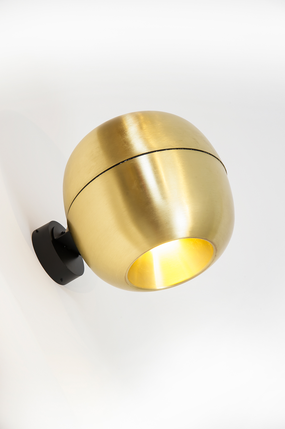 Wall light in the shape of a small golden apple. Dark. 